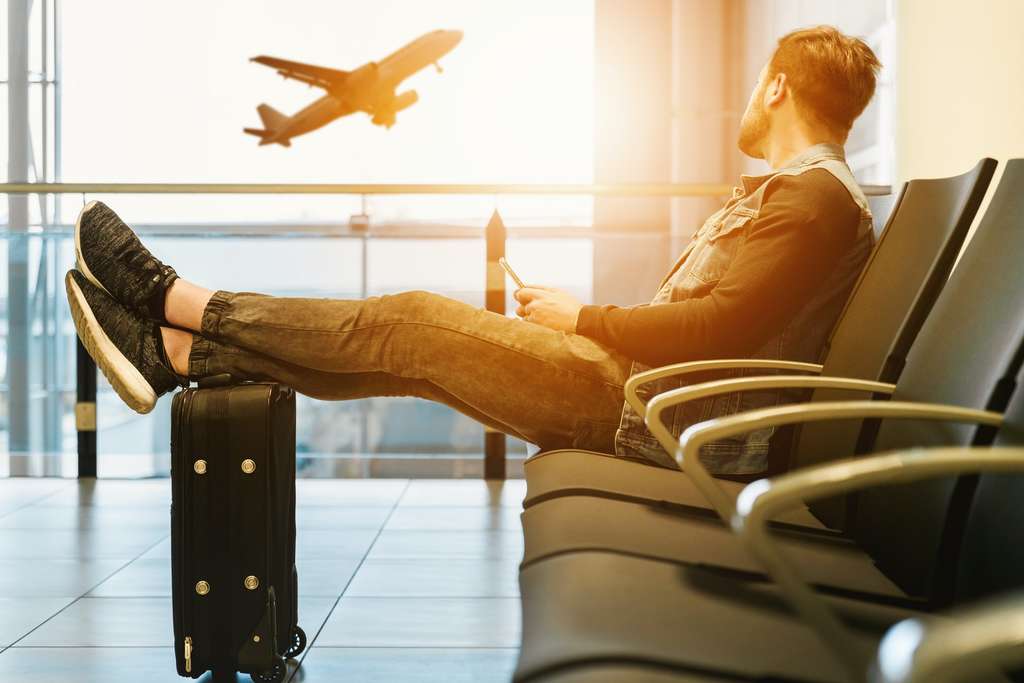 man in airport watching plane