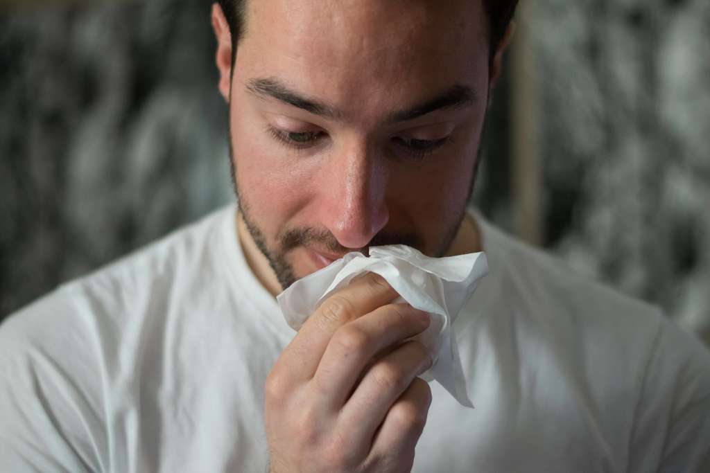 man wiping his nose