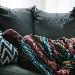 sick person laying down on couch