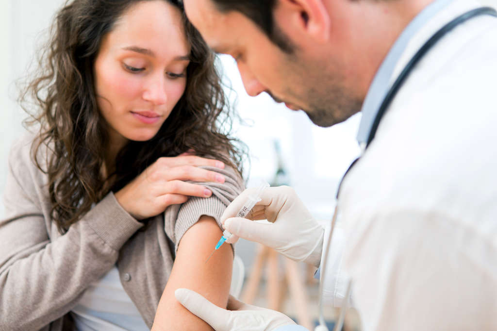Doctor giving a woman a vaccine injection