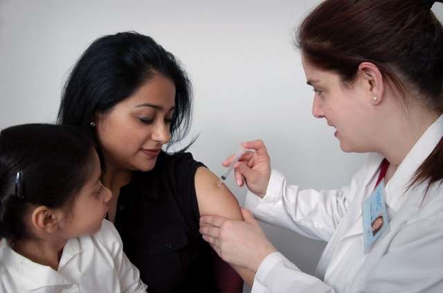 doctor giving mom vaccine
