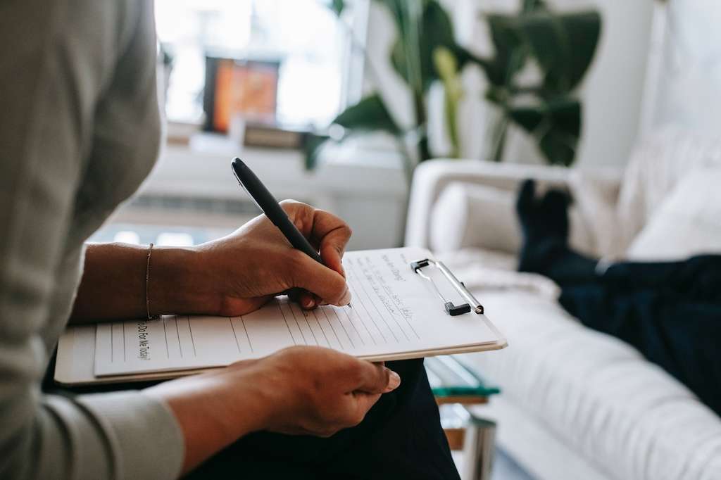 A person filling out medical forms on a clipboard