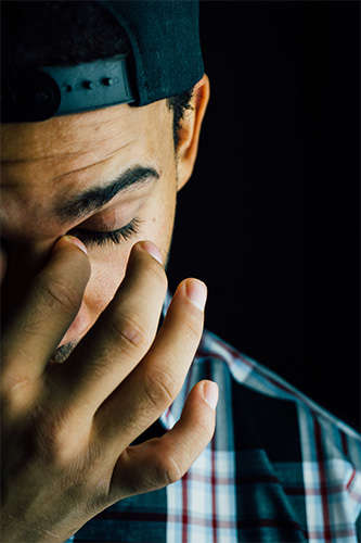 man pinching bridge of nose with fingers