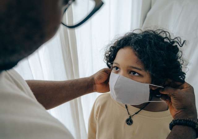 parent putting mask on child